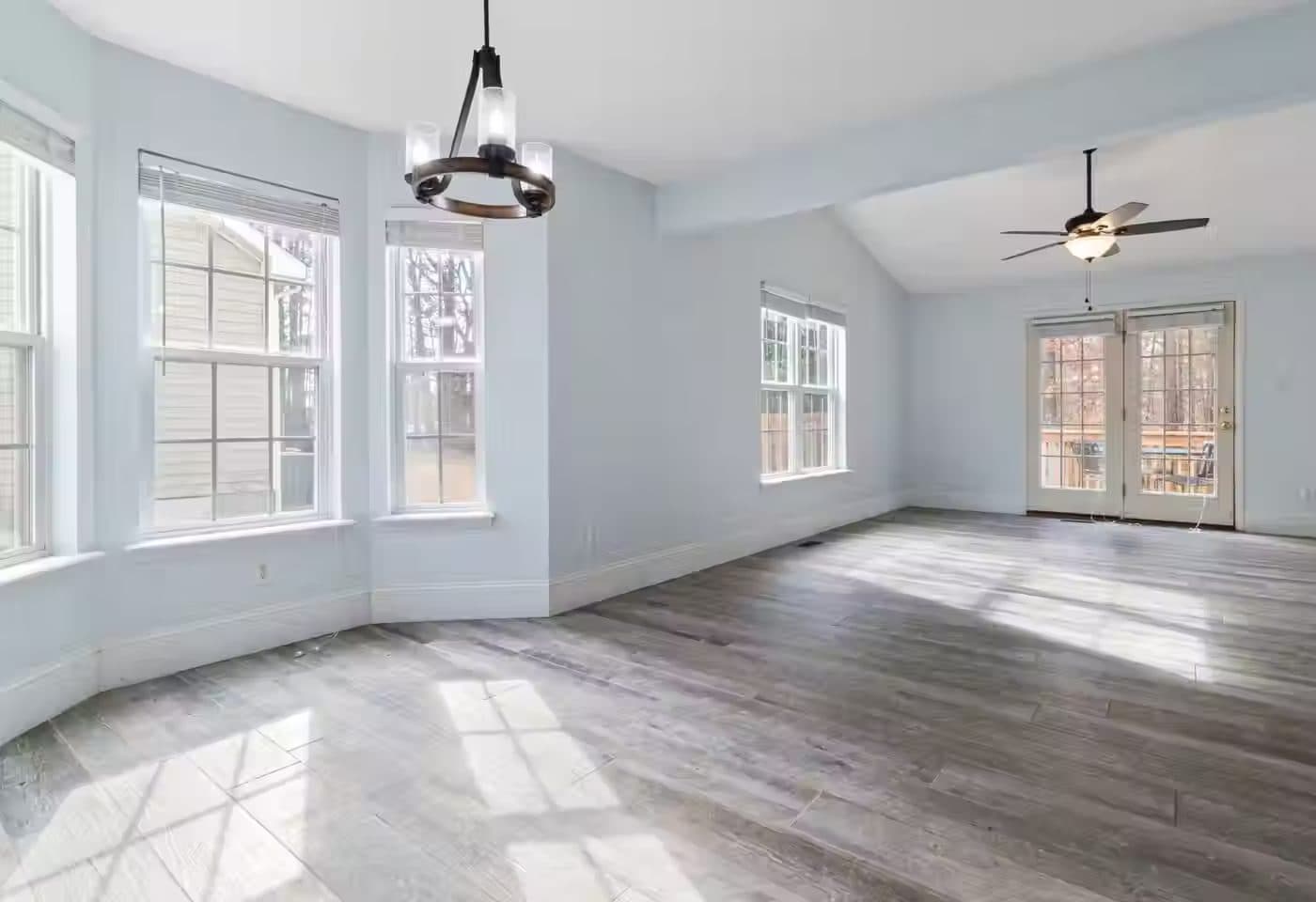 An empty room with a gray wood-look floor